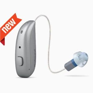 GN ReSound NEXIA miniRIE hearing aid in graphite grey, placed next to compact charger on white background.